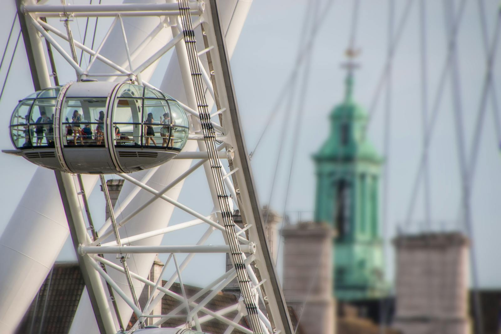 Detailed view of the London Eye capsule with blurred city architecture in the background, showcasing modern design.